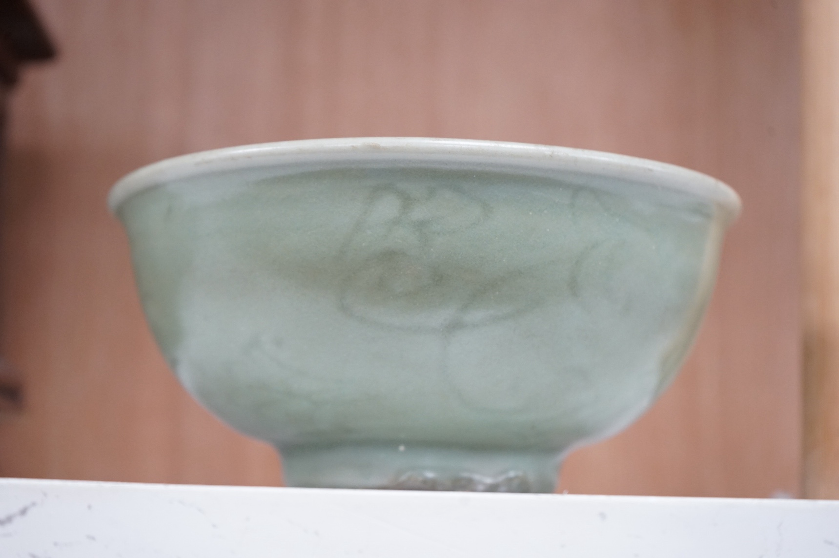 A Chinese celadon glazed bowl with incised decoration, 16cm diameter. Condition - good